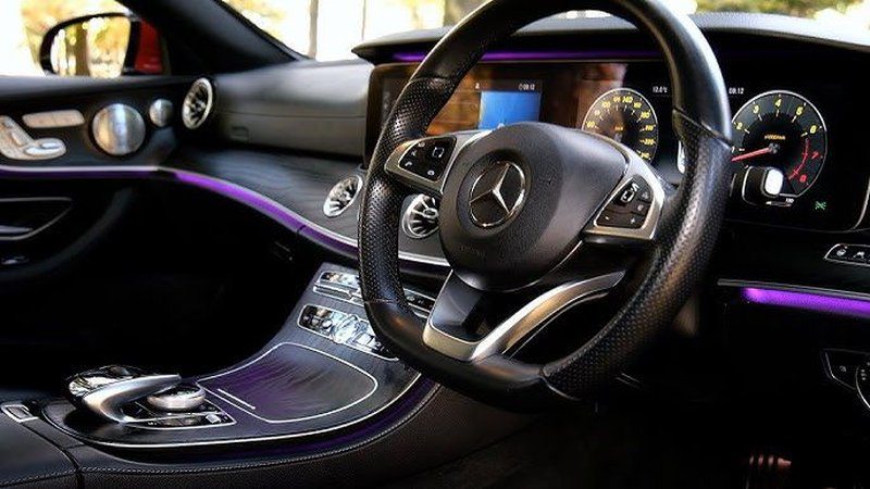 Mercedes-Benz E-Class steering wheel and ambient interior lighting — Travel in Style Essex chauffeur car interior